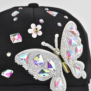 Black baseball cap featuring a white 3D butterfly design with colorful rhinestones