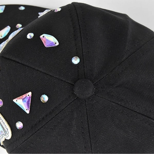 Close-up of black baseball cap texture with shimmering crystal rhinestones and top button