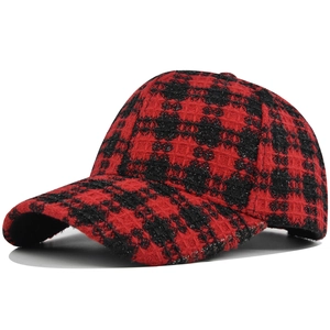 Detail of red and black plaid tweed baseball cap featuring shimmering metallic threads