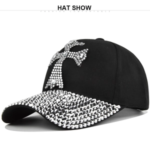Détail d'une casquette de baseball noire en coton avec croix en strass et bord orné