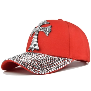 Casquette rouge avec croix en strass argentés et visière ornée de pierres brillantes