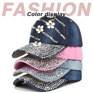 Detailed color display of denim baseball caps with rhinestones and white flower accents