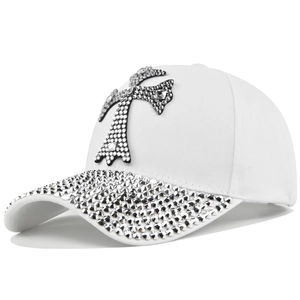 Détail d'une casquette blanche en coton avec une croix en strass et visière scintillante