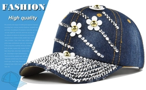 Detailed view of dark blue denim baseball cap featuring 3D white flowers and silver rhinestones