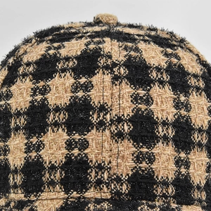 Close-up macro of tweed baseball cap fabric with black and coffee plaid texture