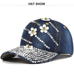 Detail of blue denim baseball cap with sparkling rhinestones and white floral 3D appliqués
