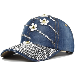 Detail of blue denim baseball cap with silver rhinestones and white floral 3D decorations