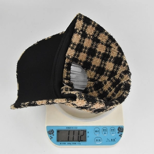 Macro shot of a plaid baseball cap on an electronic scale showing weight of 111.2g