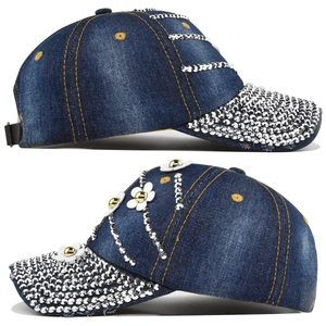 Detail of blue denim baseball cap featuring sparkling rhinestones and white floral ornaments