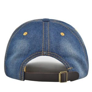 Close-up of blue denim baseball cap back with yellow stitching and leather strap