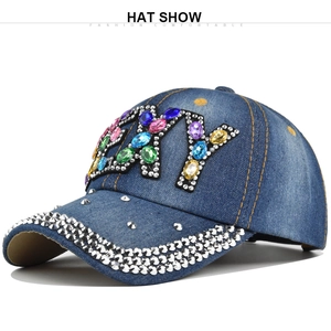 Detail of silver rivets and crystal NY logo on navy denim baseball cap crown