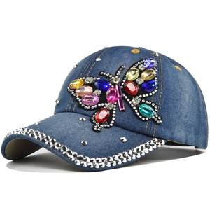 Blue denim baseball cap with a colorful rhinestone butterfly and silver rivet accents