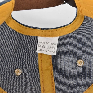 Detailed macro view of 100% cotton denim baseball cap inner seams and wash label