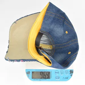 Detailed view of denim baseball cap weighing 96.9g on digital scale with vintage frayed brim