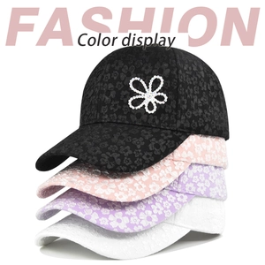 Close-up of floral textured baseball caps with rhinestone flower logo in four colors