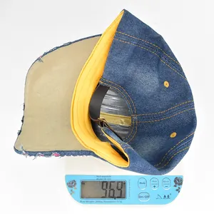 Detailed top view of a blue denim skull baseball cap on a digital scale weighing 96.9g