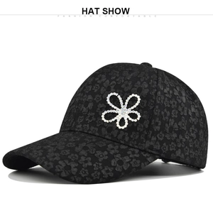 Macro view of black baseball cap with relief floral texture and sparkling rhinestone flower