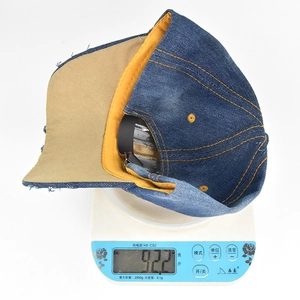 Detailed view of the dark blue denim baseball cap on a scale weighing 92.2 grams