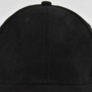 Détail macro d'une casquette en daim noir avec coutures doubles et bouton supérieur