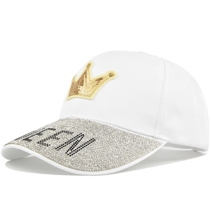 Close-up of golden crown patch and QUEEN rhinestone lettering on a white baseball cap