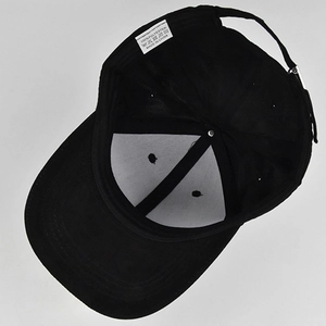 Détail de la casquette de baseball en daim noir montrant l'étiquette et la boucle métallique