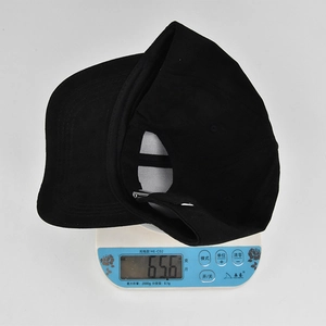Détail de la boucle métallique ajustable sur une casquette de baseball noire en daim synthétique