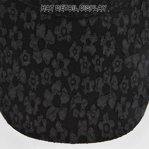 Macro view of black baseball cap fabric showing detailed 3D floral jacquard texture