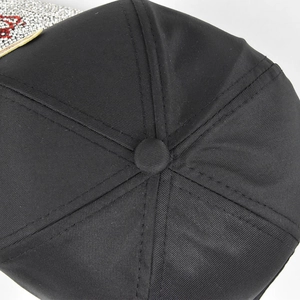 Detailed macro view of the black baseball cap crown with stitched panels and rhinestone edge