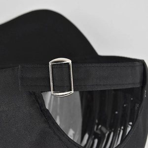 Close-up of the adjustable back strap with silver metal buckle on a black baseball cap