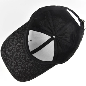 Detailed view of the black baseball cap's internal structure and textured lace fabric