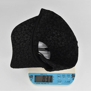 Detail showing the lightweight 83.1g weight of the black floral baseball cap on a digital scale