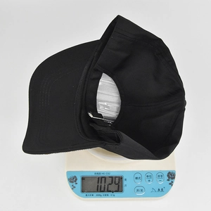 Weight display of black rhinestone baseball cap on digital scale showing 102.9 grams