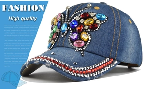 Dettaglio del motivo a farfalla con strass colorati su berretto in denim blu