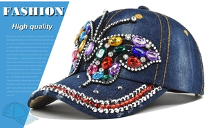 Close-up of butterfly rhinestone patterns on a dark blue denim baseball cap detail