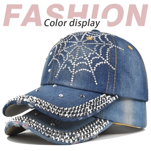 Detail of blue denim baseball cap featuring silver rhinestone spiderweb and embroidery