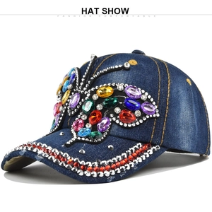 Detail of colorful butterfly pattern made of rhinestones on blue denim baseball cap