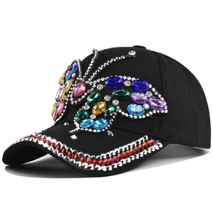 Black cotton baseball cap featuring a large colorful rhinestone butterfly and jeweled brim