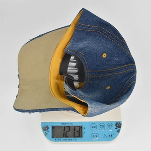 Misurazione dettagliata del peso di 121,3 g per il berretto da baseball in denim su scala