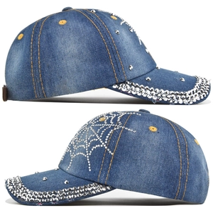 Detail view of blue denim baseball cap with rhinestone spider web and silver studs
