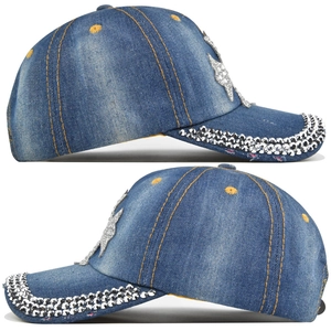 Detail of blue denim baseball cap with rhinestone brim and sparkling butterfly patch