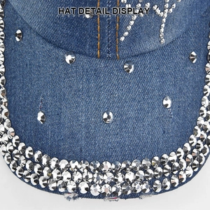 Close-up of sparkling rhinestones on blue denim baseball cap with orange stitching
