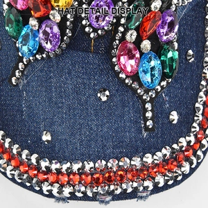 Detail view of denim baseball cap brim featuring colorful rhinestones and sparkling crystals