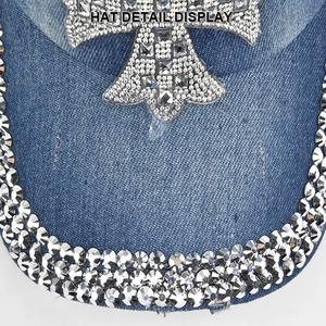 Detailed close-up of shiny rhinestones on a cross patch of a blue denim baseball cap