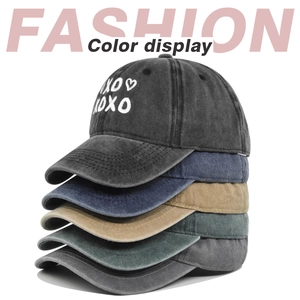 Detailed stack of washed vintage baseball caps with XOXO embroidery in five colors