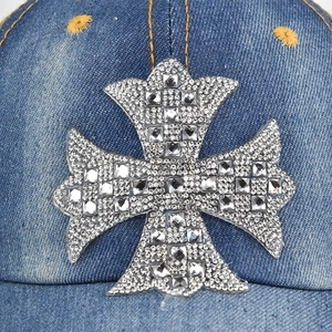 Blue denim baseball cap featuring a large rhinestone encrusted cross pattern on the front
