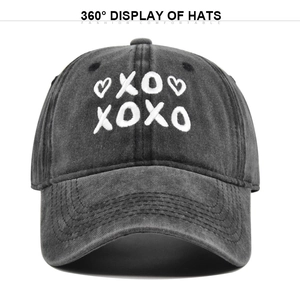 Detailed close-up of white XOXO heart embroidery on a vintage washed grey baseball cap