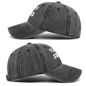 Detail view of charcoal grey washed denim cap featuring white XOXO heart embroidery