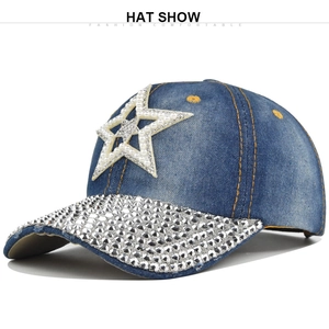 Détail d'une casquette en denim bleu avec bord en strass et étoile en perles