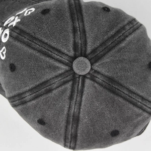 Detailed macro of white 3D embroidery on washed cotton fabric of dark grey baseball cap