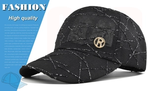 Close-up of black textured baseball cap with metallic R logo and silver thread patterns